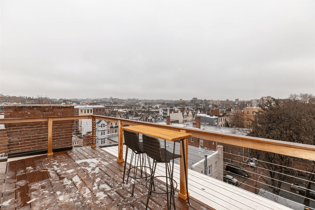 a balcony with a table and chairs and a view of the city